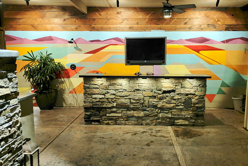 outdoor bar with colorful mural.